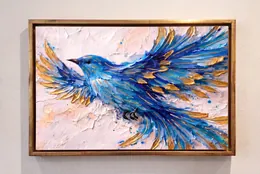A blue textured bird with gold details, framed on a wall